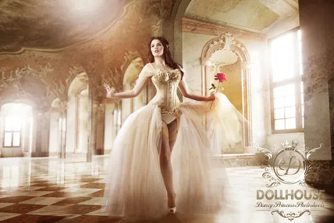 Client in cream corset gown and tiara in ornate palace with rose accessory, princess-inspired styling